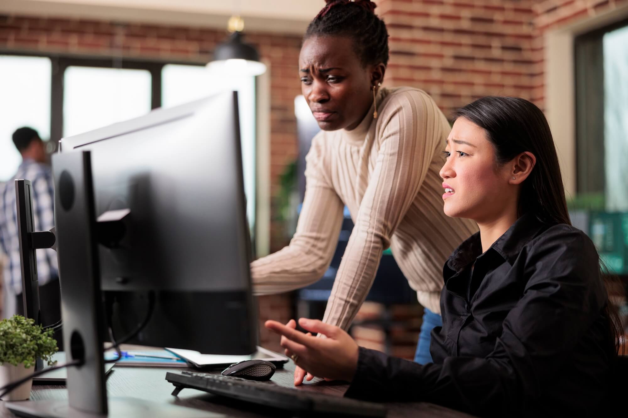 Two women in office looking at computer monitor wondering why their website isn't showing up in Google